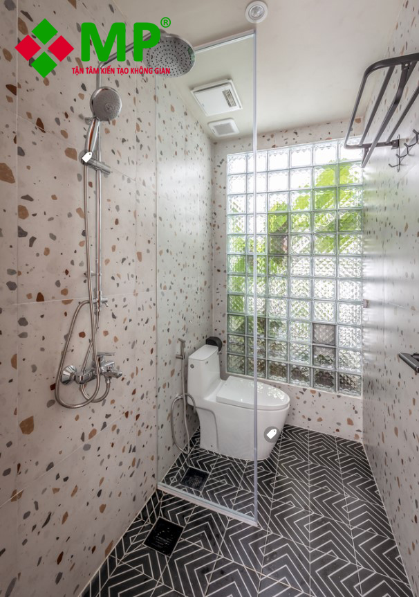 Nhà vệ sinh nhà ống 4.5m có tường gạch kính giúp không gian tận dụng ánh sáng tự nhiên